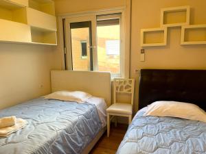um quarto com 2 camas, uma cadeira e uma janela em Quiet Apartment near Tirana Lake em Tirana