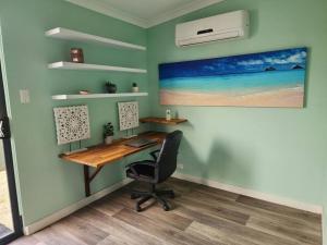 a home office with a desk and a painting on the wall at Cozy Pet-Friendly Escape Goreng Boodja Maya-Maya in Bremer Bay