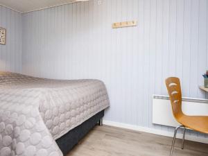 1 dormitorio con 1 cama, 1 mesa y 1 silla en Holiday home Hemmet XI en Hemmet