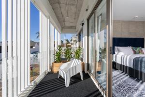 a bedroom with a bed and a balcony with windows at Arluxia in Auckland +62 photos