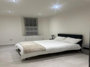 biała sypialnia z dużym łóżkiem w obiekcie Charming 1-Bed Apartment in Walton on the Naze w mieście Walton-on-the-Naze