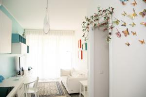 a white room with a white couch and butterfly wall decals at DiBa House 46 in San Vito Chietino