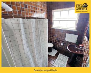 a bathroom with a toilet and a shower curtain at Casa Amarela Blumenau Hospedagem Alternativa in Blumenau
