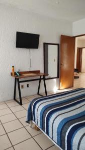 a bedroom with a bed and a table with a television on the wall at Planta alta 3 recamaras centro Guadalajara in Guadalajara