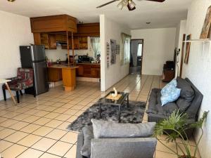 a living room with a couch and a kitchen at Planta alta 3 recamaras centro Guadalajara in Guadalajara