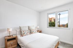 Breña AltaにあるLa Grama I comodidad y excelente ubicaciónの白いベッドルーム(ベッド1台、窓付)