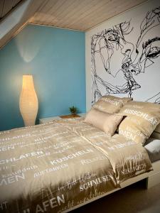 Schlafzimmer mit einem Bett mit Wandgemälde in der Unterkunft neXt doOr Donau Gästezimmer und Suite in Wurmlingen