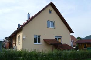 ein gelbes Haus mit braunem Dach in der Unterkunft neXt doOr Donau Gästezimmer und Suite in Wurmlingen