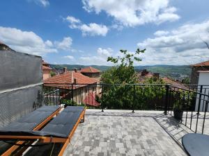 a patio with a bench on a balcony at PANORAMNA -Guest Rooms in Veliko Tŭrnovo