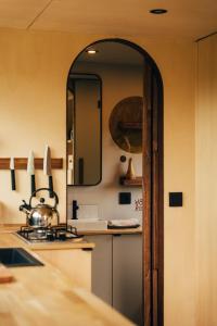 eine Küche mit einer Theke mit einem Spiegel und einem Waschbecken in der Unterkunft Tiny House Au Coeur de la Campagne Wallonne in Chaumont-Gistoux