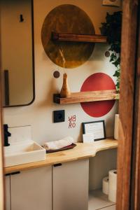 a bathroom with a counter with a sink and a mirror at Tiny House Au Coeur de la Campagne Wallonne in Chaumont-Gistoux