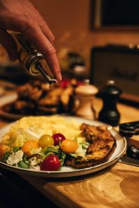 uma pessoa está preparando um prato de comida em uma mesa em Tiny House Au Coeur de la Campagne Wallonne em Chaumont-Gistoux