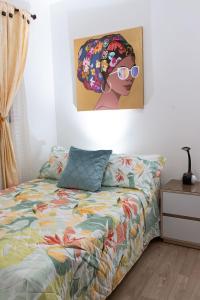 um quarto com uma cama e uma pintura de uma mulher com óculos de sol em Hospedaje juandi em Medellín