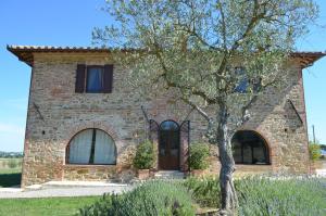 a brick house with a tree in front of it at Podere Molinaccio in Panicale