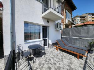 a balcony with a couch and a table and chairs at PANORAMNA -Guest Rooms in Veliko Tŭrnovo