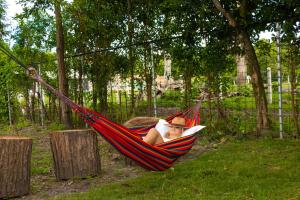 a woman laying in a hammock with a book at Glamping Domo Ibagué in Ibagué