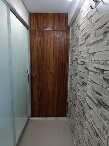 Studio Arenas في أريكيبا: ممر مع باب خشبي وجدار حجري +صورتان