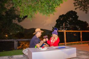 a man and woman sitting at a table drinking wine at Glamping Domo Ibagué in Ibagué