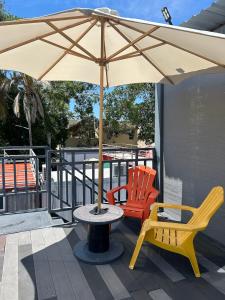 een tafel met een paraplu en twee stoelen op een terras bij Casa Garfio in Barra de Navidad