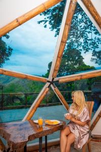 a woman sitting at a table in a gazebo at Glamping Domo Ibagué in Ibagué