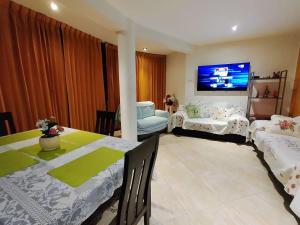 sala de estar con mesa de comedor y TV en Apartamento en el corazón de Trujillo, en Trujillo