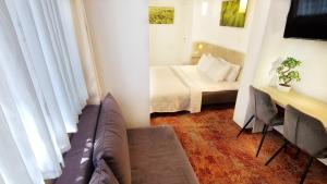 Vivulskis Apart-Hotel في فيلنيوس: غرفه صغيره فيها سرير واريكه