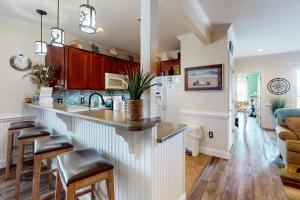 a kitchen with a sink and a counter with stools at Sunrise Paradise in Hatteras