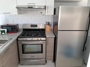 a kitchen with a stainless steel stove and refrigerator at Pool View Punta Cana in Punta Cana