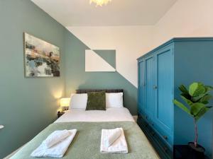 a bedroom with a bed and a blue cabinet at Temple Bar Central Apartment in Dublin