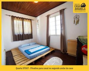 Habitación pequeña con cama y ventana en Casa Amarela Blumenau Hospedagem Alternativa en Blumenau