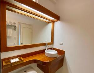 a bathroom with a sink and a large mirror at Torre Mar Galapagos Boutique Suites in Puerto Ayora