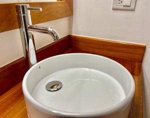 lavabo blanco con grifo en el baño en Torre Mar Galapagos Boutique Suites, en Puerto Ayora