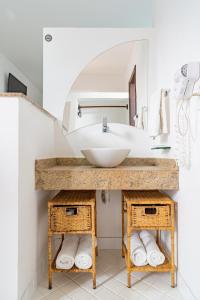 uma casa de banho com um lavatório e um espelho em Pousada Porto Fino em Cabo Frio