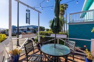 a table and chairs on a balcony with an umbrella at Pleasant Inn in Morro Bay