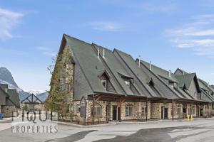 a building with a large roof on a street at Mystic Mountain Chalet, Heated Outdoor Pool & Hot Tub, Free Parking, Fast Wifi! in Canmore