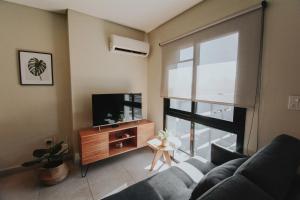 a living room with a couch and a tv at 8) Hermoso departamento cómodo y equipado! in Godoy Cruz