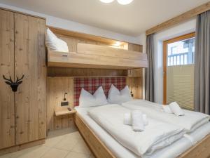 ein Schlafzimmer mit einem Etagenbett mit weißen Kissen in der Unterkunft Arianne Ski in - Ski out in Saalbach-Hinterglemm