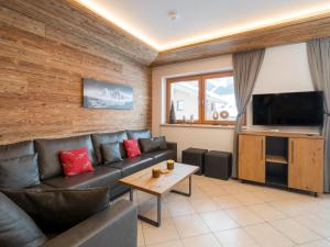 ein Wohnzimmer mit einem Sofa und einem Flachbild-TV in der Unterkunft Arianne Ski in - Ski out in Saalbach-Hinterglemm