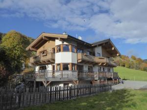 ein großes Haus mit einem Zaun davor in der Unterkunft Arianne Ski in - Ski out in Saalbach-Hinterglemm