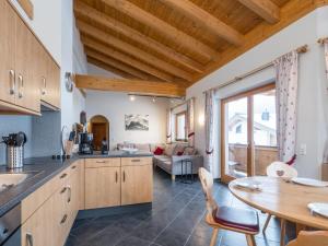 a kitchen and living room with a table and chairs at Traumlage Ski in - Ski out in Saalbach Hinterglemm