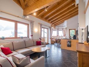 a living room with a couch and a table at Traumlage Ski in - Ski out in Saalbach Hinterglemm
