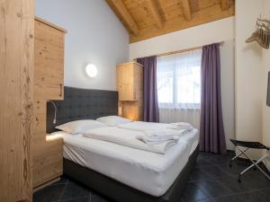 a bedroom with a large bed and a window at Traumlage Ski in - Ski out in Saalbach Hinterglemm