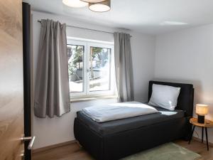 - un lit dans une chambre avec fenêtre dans l'établissement Tirolee Marchegg, à Wildschönau