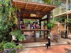 a woman standing in a flower shop with a dog at Family house - stay on pine hill Dalat in Xuan An
