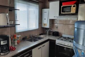 a kitchen with a sink and a stove and a microwave at Apartamento en Buenos Aires in Buenos Aires