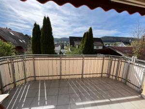 einen Balkon mit einem Holzzaun und Bäumen in der Unterkunft neXt doOr Donau Gästezimmer und Suite in Wurmlingen