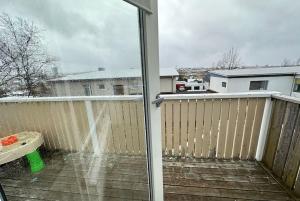 a balcony with a sliding glass door with snow on it at House in Hlíðarvegur, Kópavogur - Birta Rentals in Reykjavík