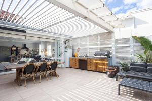 een patio met een tafel en stoelen en een keuken bij Modern Muse, Bellevue Hill in Sydney