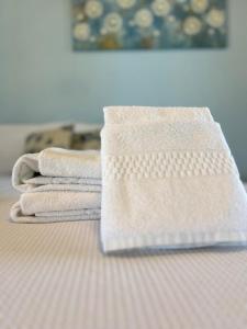 uma pilha de toalhas sentadas em cima de uma cama em Pousada Recanto Rainha do Lago em Capitólio