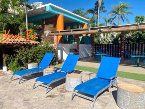 three blue chairs sitting in front of a resort at Suites Acapulco Yamba in Acapulco